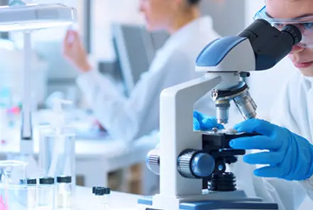 lab technician using a microscope